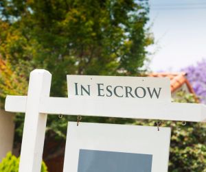For Sale sign with "In Escrow" sign attached